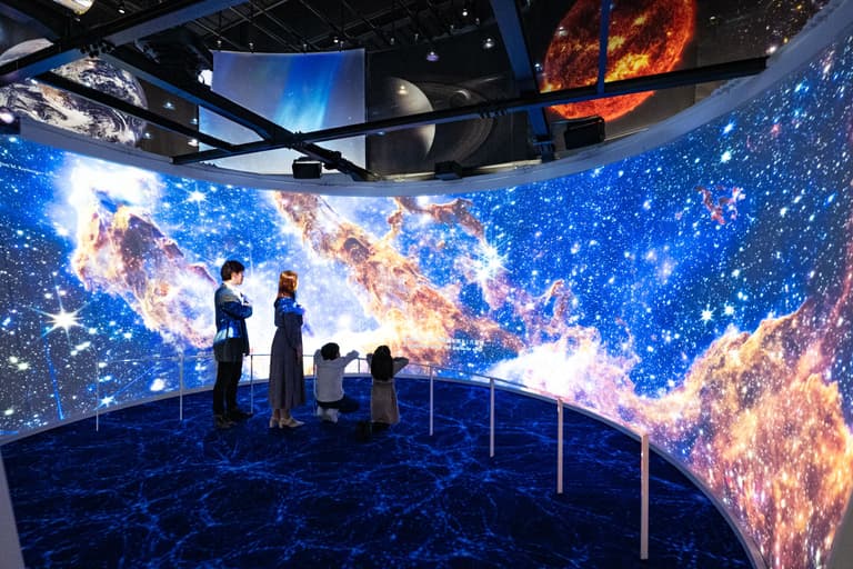 【スペースタイムアドベンチャー】⼤きな円形シアターの中で、宇宙のはじまりからファーストスターや銀河、さらに⽣命の誕⽣まで、迫⼒の⼤画⾯ で体感できます。