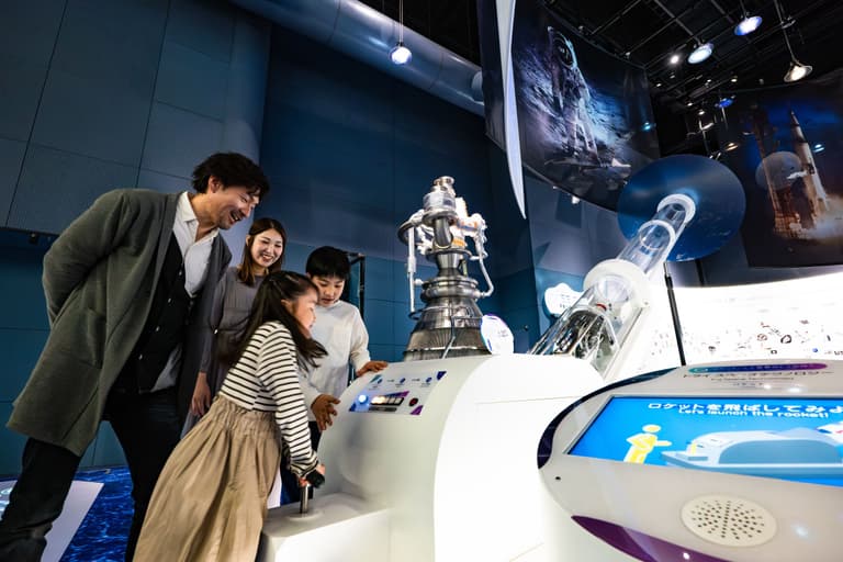 【トライスペーステクノロジー】ロケットや⼈⼯衛星の原理や仕組みを、実験装置を使って体験し、解説モニターでより詳しく知ることができます。